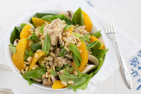 Tuna salad over romaine with orange slices and pine nuts.