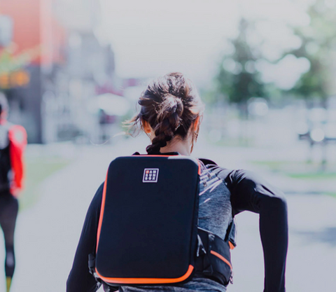 Woman running wearing IAMRUNBOX Backpack Pro