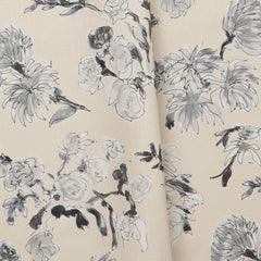 Folded linen swatch with a pattern of large-scale line-drawn flowers in black ink with gray watercolor, on a beige background.
