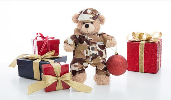 Teddy bear in military uniform in the middle of a set of gifts