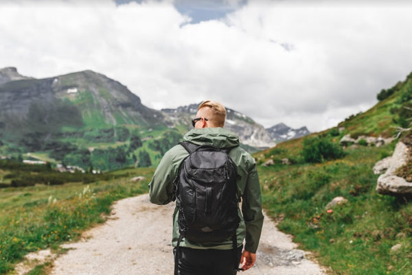 Man with a backpack walking along a mountain path