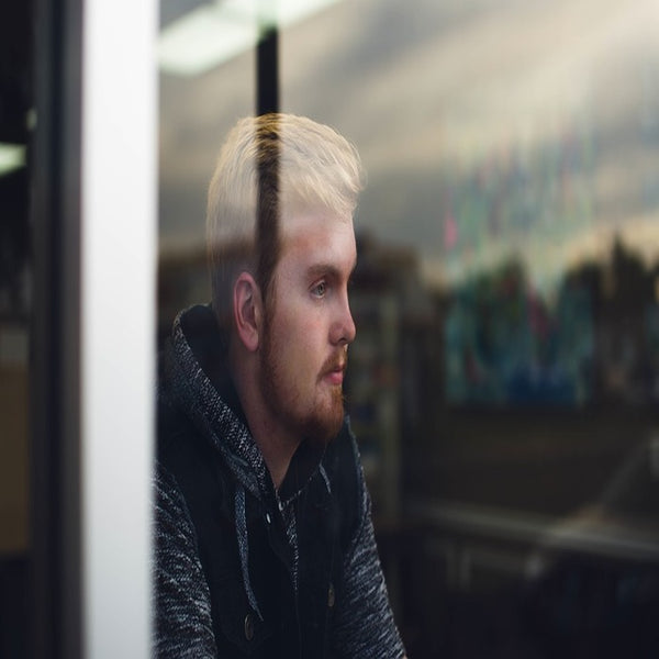 A blonde, bearded man staring out the window