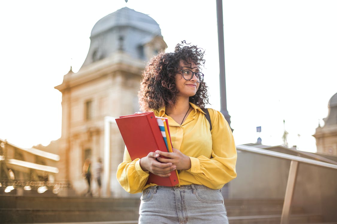 college student on campus carrying notebook