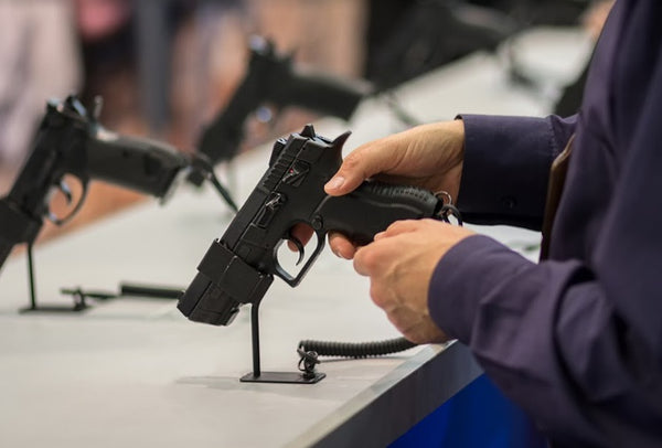 A person trying a handgun at a gun exhibition