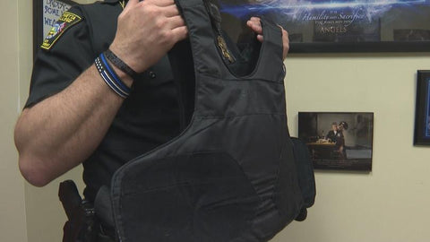 Police officer holding up a concealable vest
