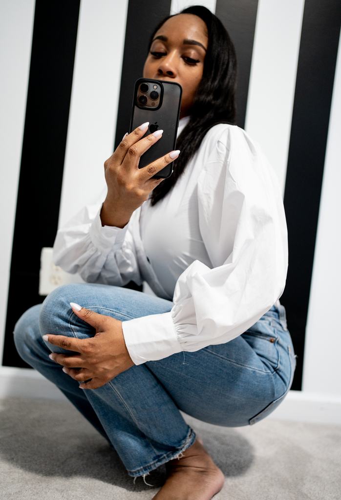 woman in a white button up shirt crouching 