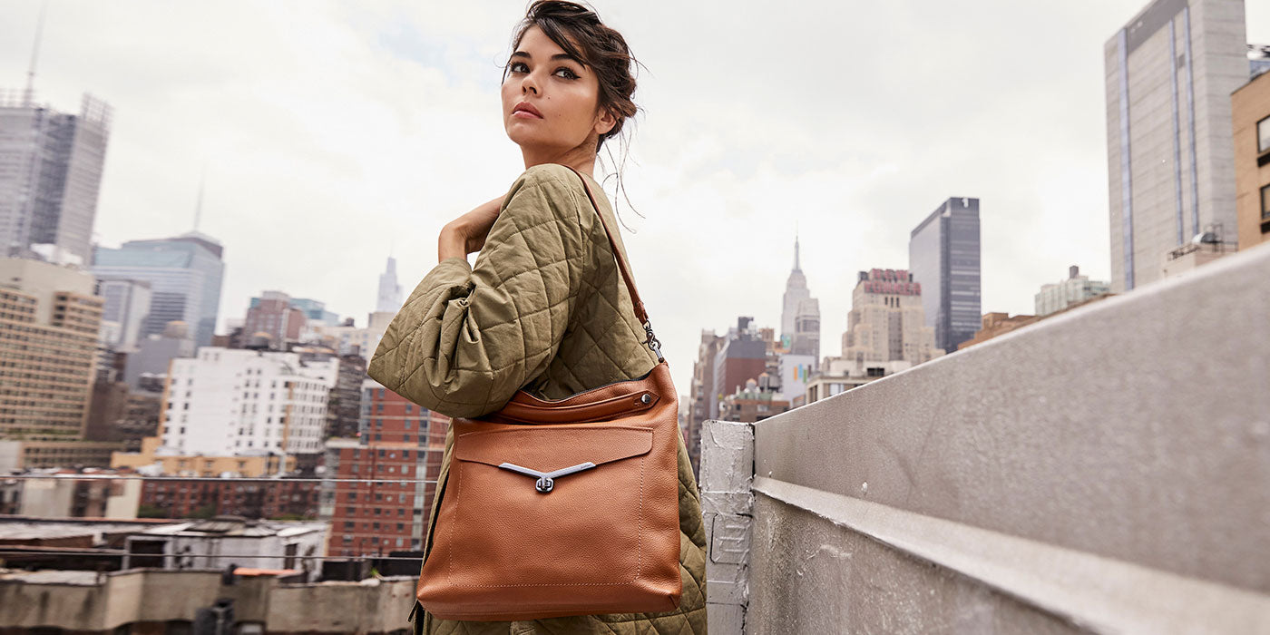 Model holding Valentina hobo in Coffee color