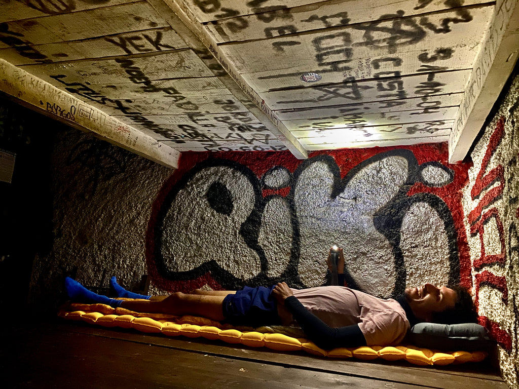 Lachlan Morton preparing for sleep in a mountain refuge