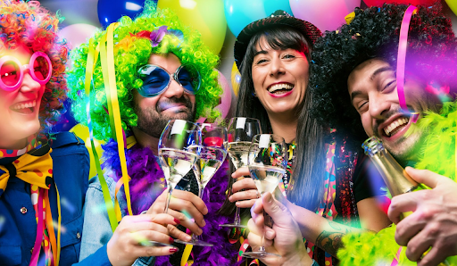 Youngsters wearing Mardi gras costumes with wigs in a party