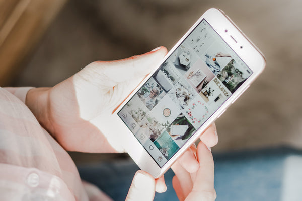 Create positive change to your social media scrolling habit by following these productivity experts on Instagram - phone shows beautiful Instagram grid