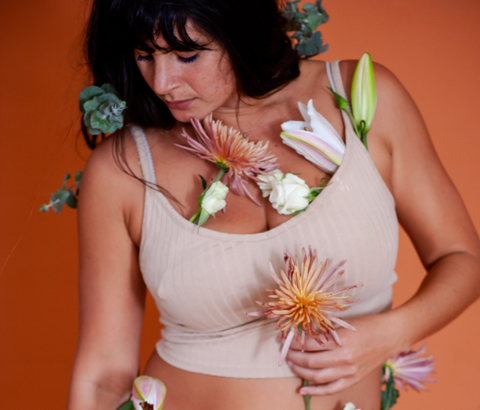 Arielle Egozi on white tank top holding flowers