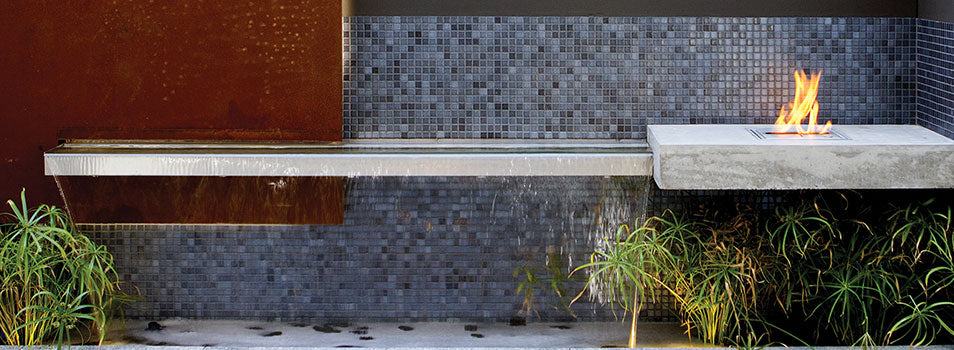 Fire pit with a waterfall ledge with tile surrounds