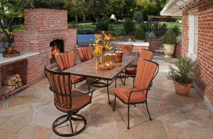 Rustic style patio furniture in a backyard with a brick fireplace