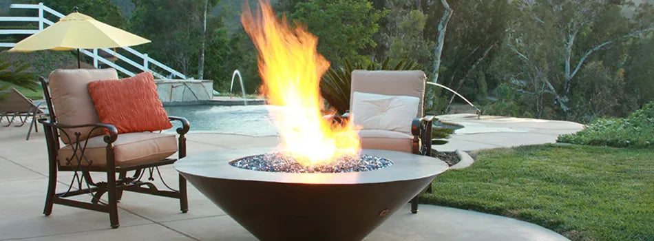 Starfire Designs Moreno copper fire pit in a backyard with very large flames
