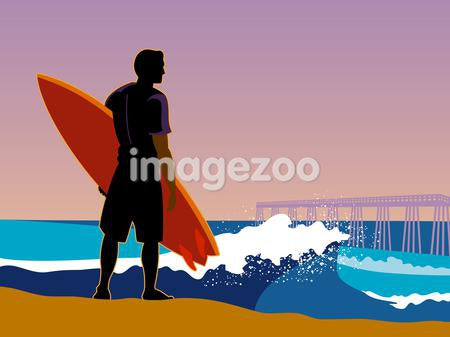 A surfer on the beach looking at the waves