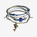 Dolphin Bracelet 4 piece set is adjustable with stackable bracelets in ocean blue and brown cords, a bronze dolphin charm and blue beads. Sea life styled and stacked bracelets. Stack these corded bracelets. Created by O Yeah Gifts!