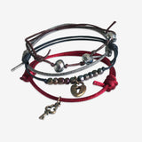 Lock & Key Bracelet 4 piece set is adjustable with stackable bracelets in wine red, brown and beige cords, a small key, heart lock charm and glimmering silver beads. Fun style stacked bracelets. Stack these corded bracelets. Created by O Yeah Gifts!