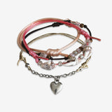 Stackable Seaside Heart Bracelet 4 piece set. Corral pink cord bracelets are adjustable. Displayed with a silver heart charm and shell beads. Ocean beach style stacked bracelets. Stack bracelets are handmade. Created by O Yeah Gifts!