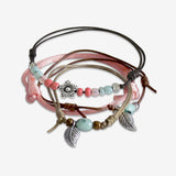 Stackable Spring Flower and Leaf Bracelet 4 piece set. Corral pink and mint green bracelet cords are adjustable. Displayed with a silver flower charm and two flower leaves. Stack bracelets are handmade. Created by O Yeah Gifts!