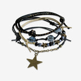 Stackable Star Bracelet 4 piece set. Gold shooting stars and black cord bracelets are adjustable. Displayed with a bronze star charm and midnight blue beads. Stack bracelets are handmade. Created by O Yeah Gifts!