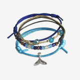 Stackable Whale Tail Bracelet 4 piece set. Blue wave bracelet cords are adjustable. Displayed with a silver mermaid tail or whale tail charm. Stack bracelets are handmade. Created by O Yeah Gifts!