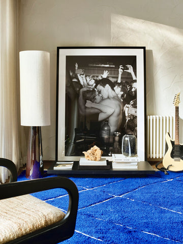 large framed black and white photo art with floor lamp and blue area rug