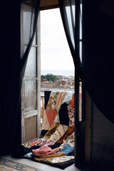 open doors to a balcony with a hand made patchwork throw blanket