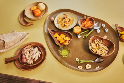 large acacia wooden platter with bowls in shape of apple, avocado, banana and pear