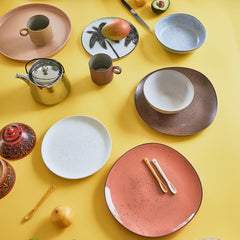 yellow table with peach, pink and orange colored ceramics