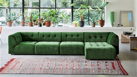 green sectional sofa with vintage area rug