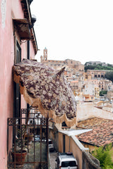 balcony overlooking town in Sicily with a retro style sun umbrella