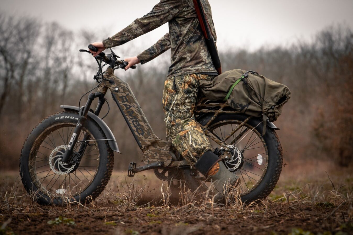 The Rambo Krusader 3.0 in Mossy Oak Bottomland with the rider standing over its step-through design frame, side profile