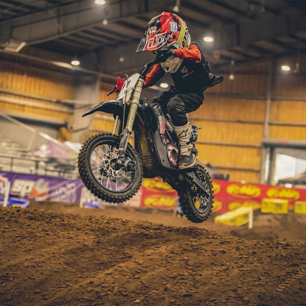 Kid riding an Electric Dirt Bike on a track 