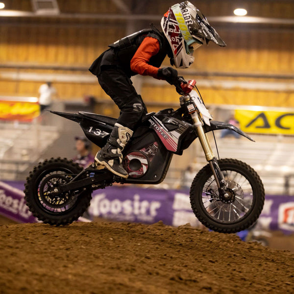 Teenager riding an electric dirt bike on the track