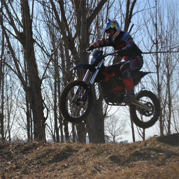 Kid riding an electric dirt bike in the woods