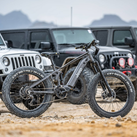 Lifestyle image of a Quietkat Jeep ebike, parked in front of multiple Jeep land rovers