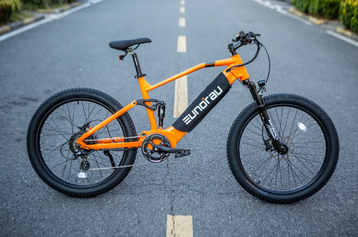 Eunorau Defender in Orange on the road, side profile