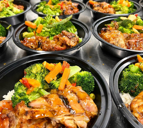 Photo of catered bowls lined up with meat and veggies