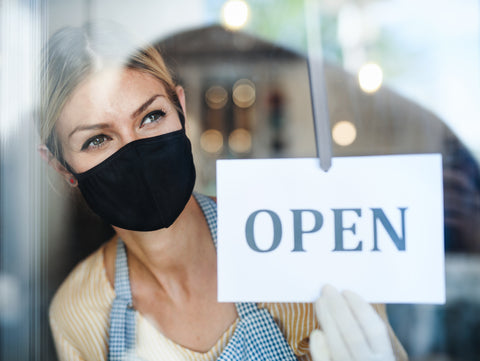 Woman with mask next to open sign