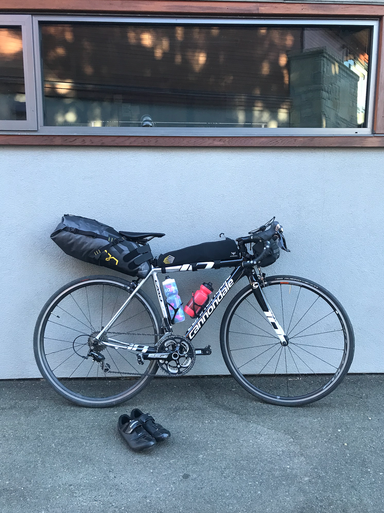 Bicycle and bicycle shoes outdoors - bike loaded with bikepacking gear.