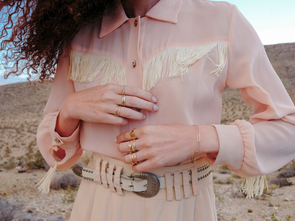 woman wearing western style clothing wearing stacks of gold rings by artist erin cuff