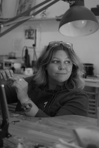 Goldsmith and Jewelry Designer Erin Cuff sits at her jewelry bench