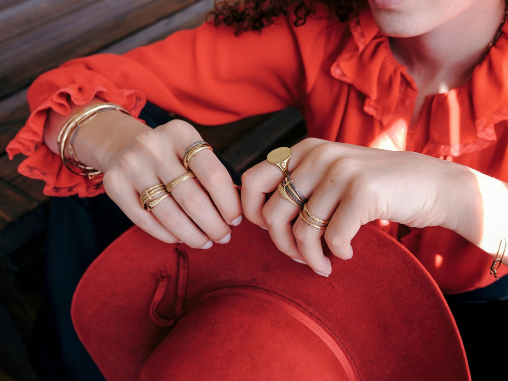 woman wearing red western style clothing and erin cuff jewelry stacked gold rings