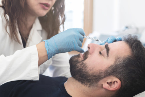 doctor injecting filler to mans forehead