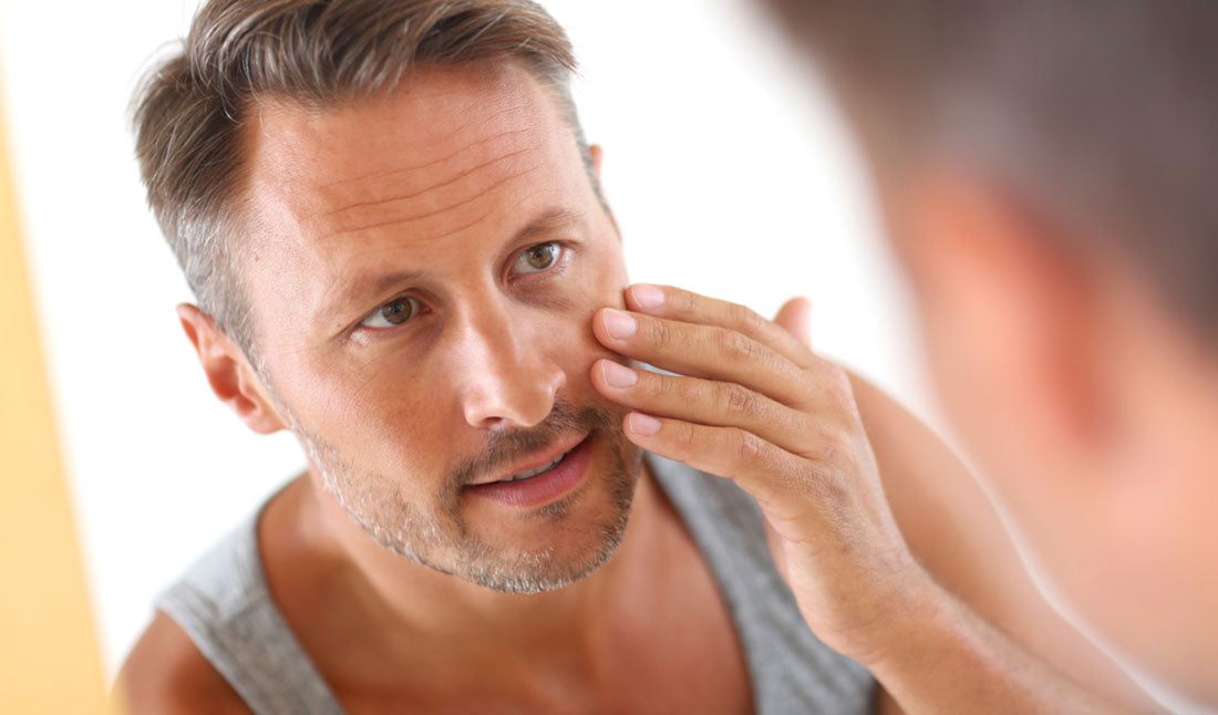 man applying cosmetics to face