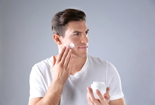 man applying face cream