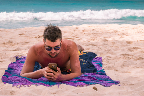 man with burned skin lying on beach