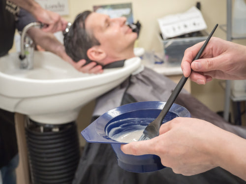 man getting hair dyed at barber shop