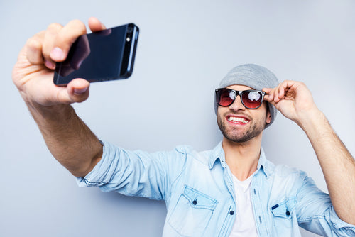 man holding phone up to take selfie