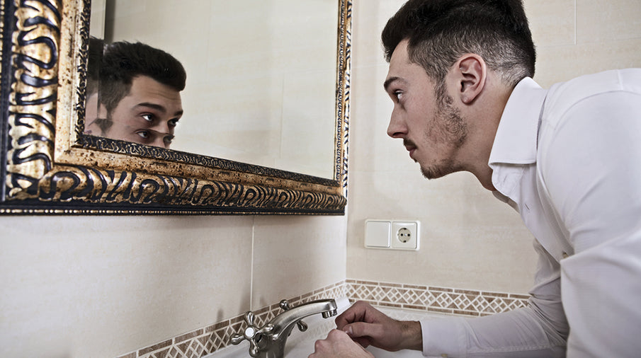 man looking at brows mirror